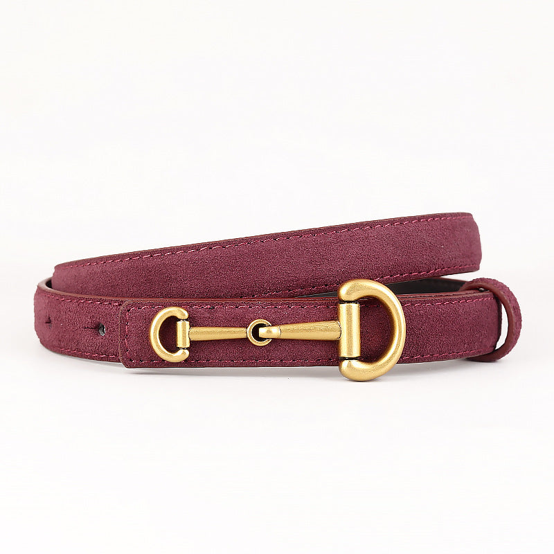 Ceinture fine pour femme Ariane en cuir suédé bordeaux avec une élégante boucle ardillon dorée inspirée d'un mors de cheval.