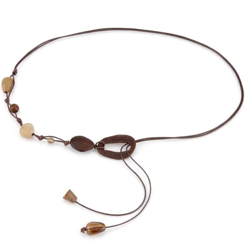 Chaîne de taille femme Calanque au style bohème chic, composée de cordons fins en similicuir tressé, agrémentée de perles en bois et d'éléments géométriques, terminée par des pampilles métalliques décoratives.