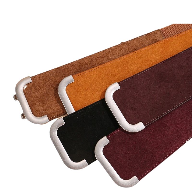 Ceinture Célia en cuir refendu effet daim, disponible en marron, orange, noir et bordeaux, avec boucle argentée en forme de double C.