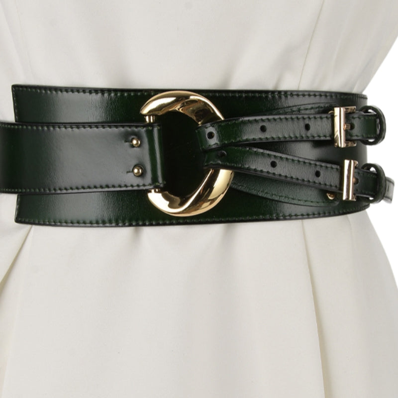 Ceinture corset large en cuir simili vert foncé avec boucle dorée et sangles ajustables, portée sur une robe blanche. #fullwidth