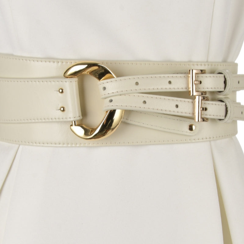 Ceinture corset blanche en cuir simili avec une boucle dorée imposante et des sangles doubles ajustables, idéale pour cintrer une robe ou une veste.