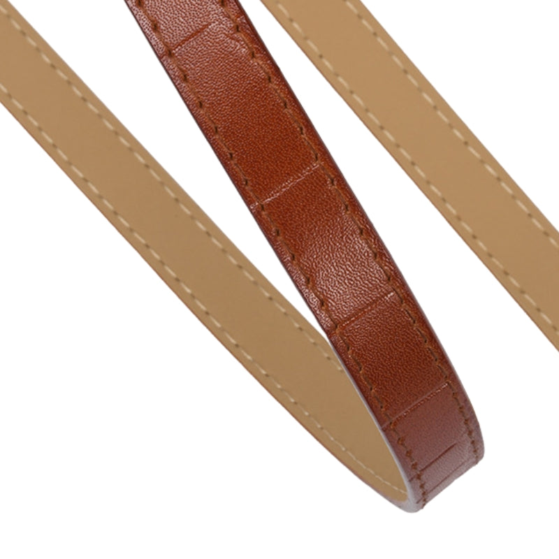Ceinture fine pour femme Élégante en cuir marron avec texture crocodile imprimée et coutures contrastantes sur fond blanc.