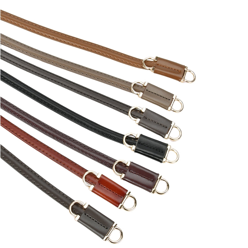 Plusieurs fines ceintures Étoile en cuir de vachette de différentes couleurs (marron clair, gris, noir, bordeaux, marron foncé) avec des finitions argentées, présentées en diagonale sur fond blanc.