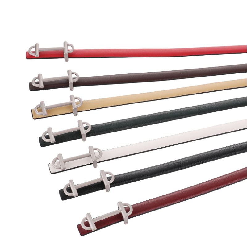 Ceintures Féerie en cuir lisse disponible en plusieurs couleurs : rouge, marron, beige, vert foncé, blanc, noir et bordeaux, avec une boucle barre cavalière argentée.
