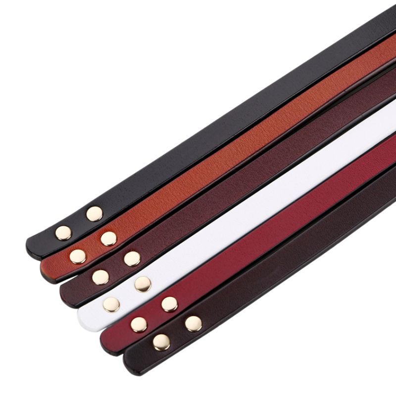 Ensemble de ceintures fines Flaminia en cuir de vachette refendu, disponibles en plusieurs couleurs (noir, marron, bordeaux, blanc, rouge, marron foncé) avec des boutons-pression dorés.