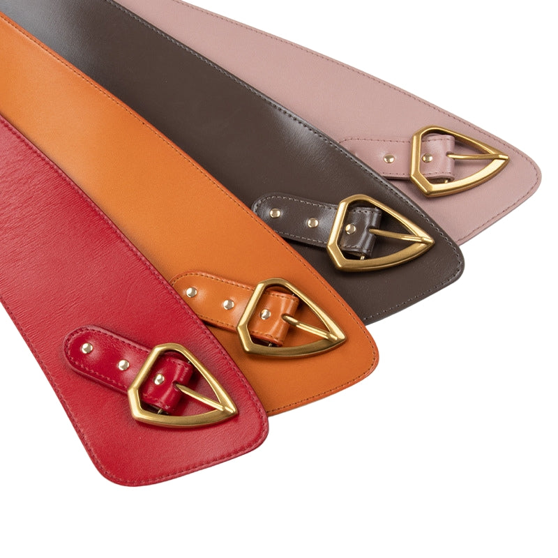 Collection de ceintures Kloé en cuir de vachette coloré : rouge, orange, marron et rose pâle. Chacune présente une boucle ardillon triangle dorée et une forme corset.