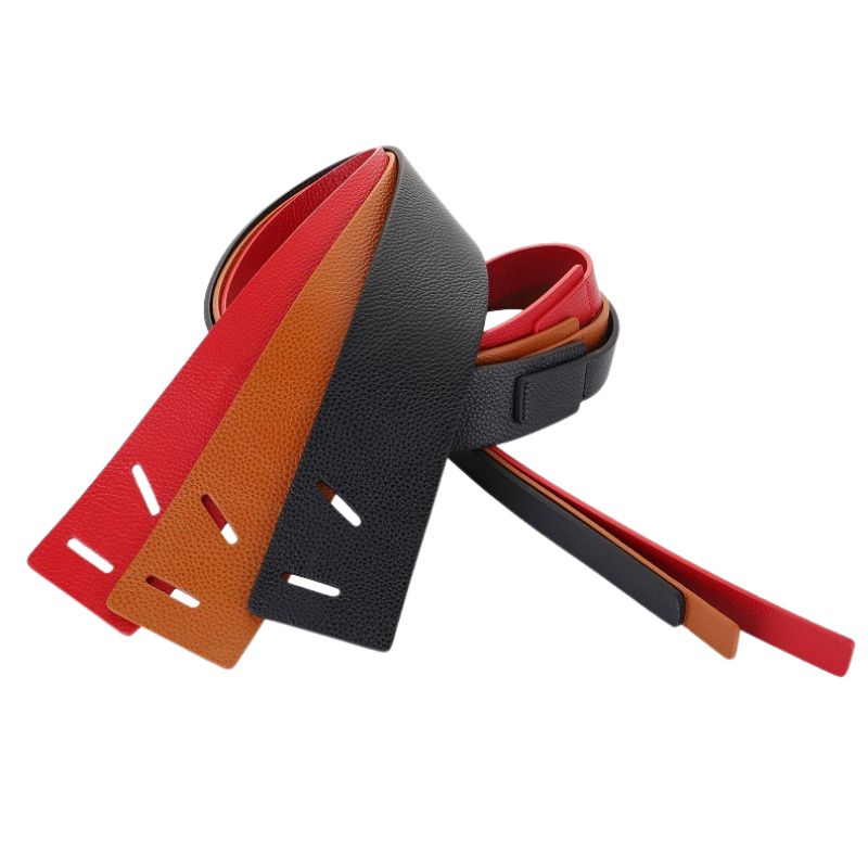 Trois ceintures Lumineusee en cuir pleine fleur grainé effet lychee, une noire, une marron et une rouge, présentées enroulées.