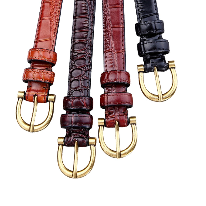 Vue rapprochée de quatre ceintures fines en cuir effet croco brillant, disponibles en marron clair, bordeaux foncé, rouge bordeaux et noir, chacune ornée d'une boucle ardillon dorée en forme de U.
