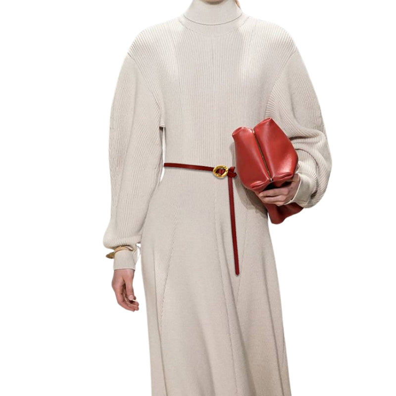 Ceinture fine rouge Ombrelle avec boucle dorée portée sur une robe longue en maille crème.
