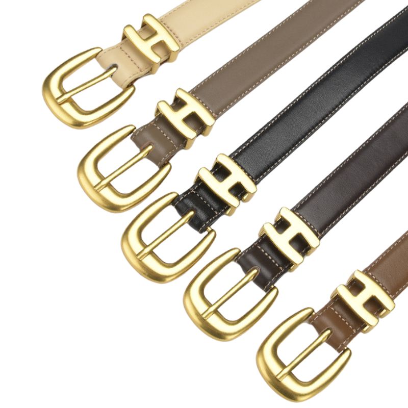 Collection de ceintures Rêveuse en cuir noir, marron foncé, gris taupe, beige et brun clair, toutes dotées d'une boucle ardillon dorée arrondie avec un motif en H.