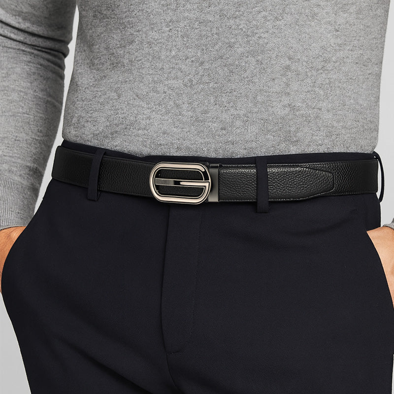 Ceinture Sacha Lux pour homme en cuir refendu noir avec boucle automatique argentée et logo "G" intégré, portée avec un pantalon bleu marine et un pull gris. #fullwidth