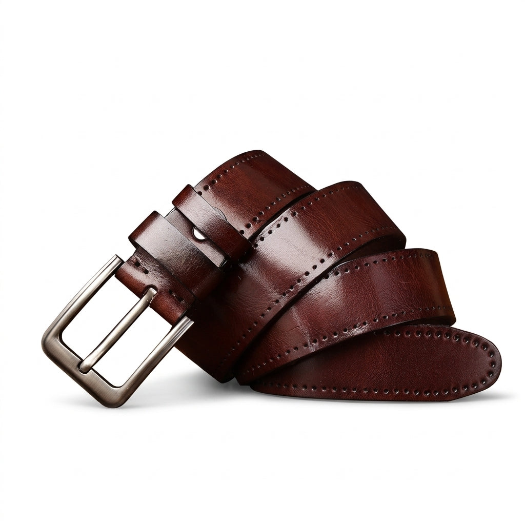 Ceinture homme Trégor en cuir de vachette pleine fleur marron avec finitions patinées vintage, surpiqûres manuelles et boucle ardillon en alliage argenté vieilli sur fond blanc.