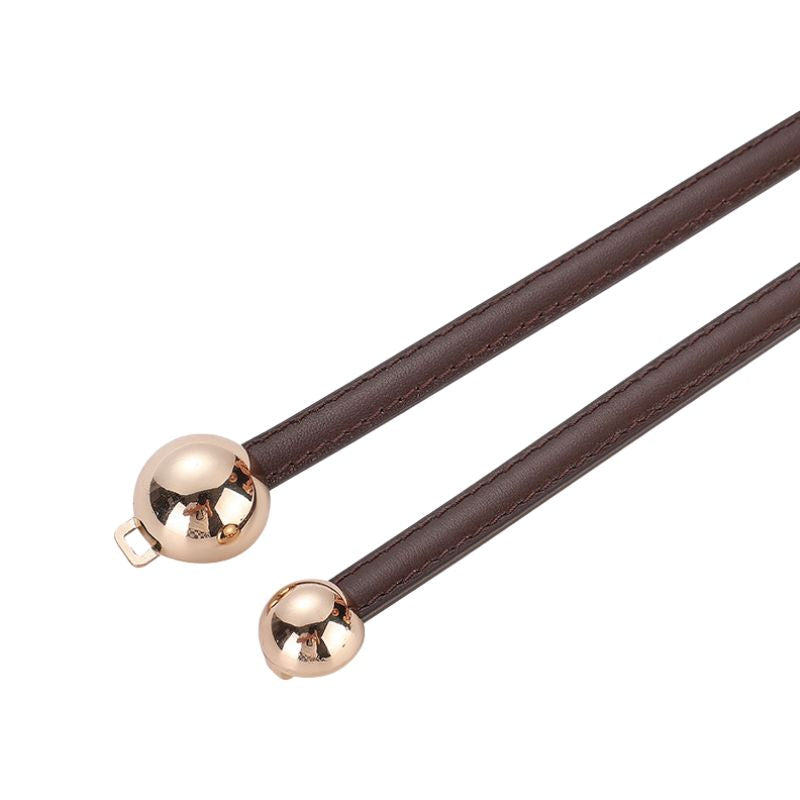 Ceinture fine Ursuline en cuir marron avec fermeture décorative à deux boules dorées.