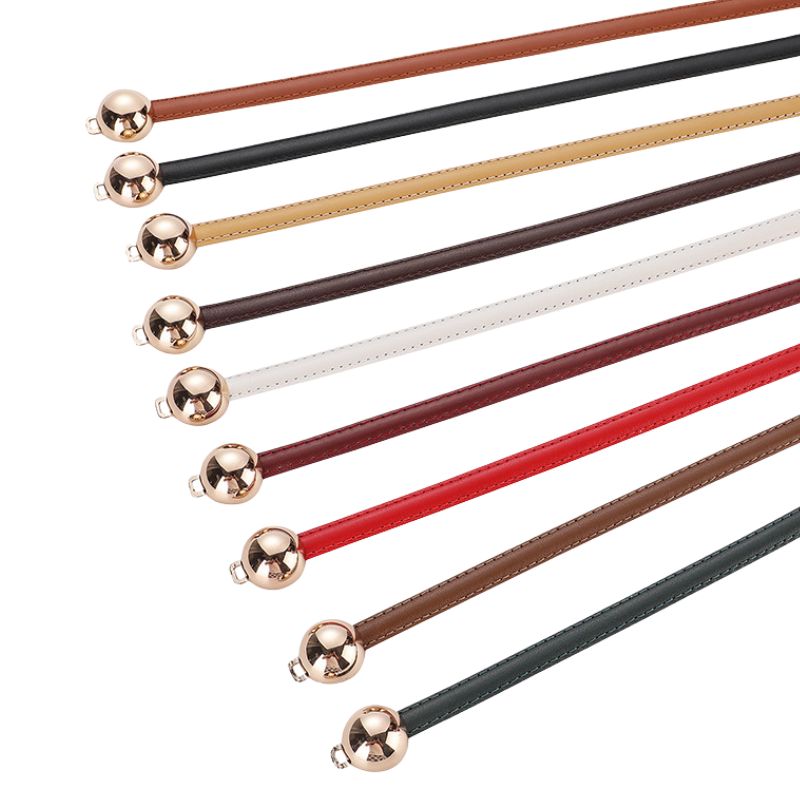 Ceintures fines Ursuline en cuir pleine fleur de vachette, disponibles en plusieurs coloris, dotées d'une fermeture décorative à deux boules dorées.