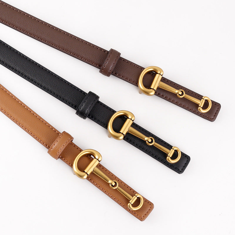 Trois ceintures fines Ariane en cuir marron, noir et camel avec boucle ardillon dorée inspirée du mors de cheval, posées sur fond blanc.