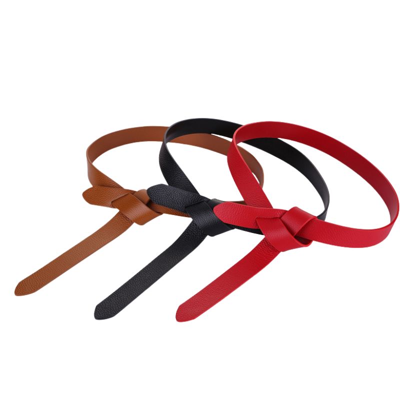 Trois ceintures fines en cuir grainé noir, rouge et marron, nouées sur le devant, de la marque Céline.