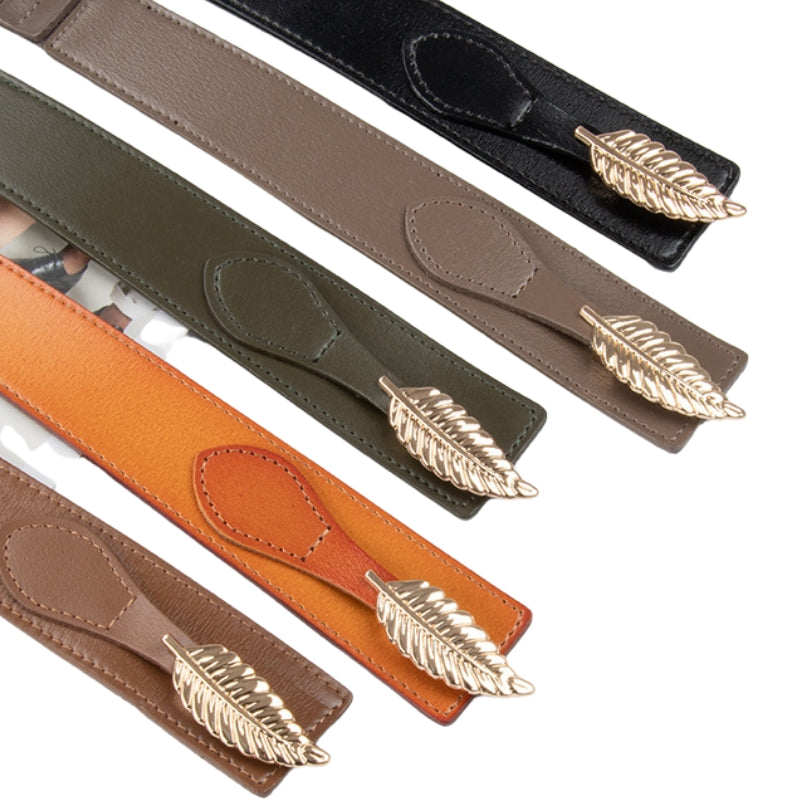 Ceinture Daphné en cuir avec boucle feuille dorée, disponible en plusieurs couleurs dont noir, taupe, kaki et orange.