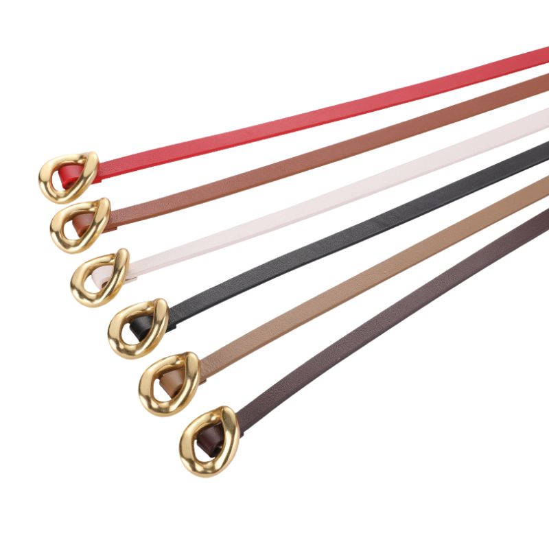 Ceinture fine Éblouie en cuir pleine fleur disponible en plusieurs couleurs (rouge, marron, blanc, noir, beige, brun foncé) avec une boucle dorée décorative et organique.