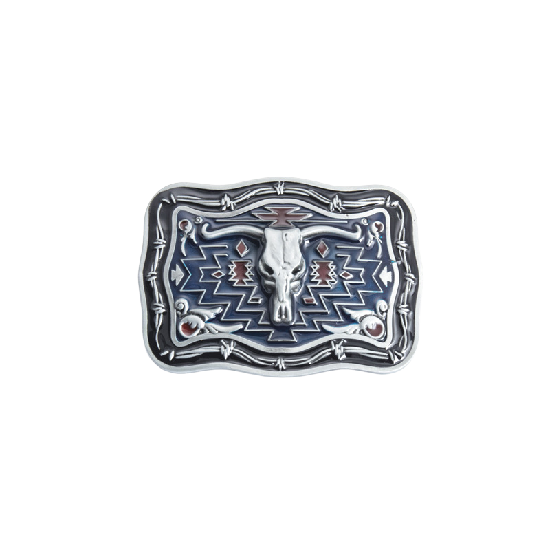 Boucle de ceinture Lame Noire pour homme, style western, avec un crâne de vache stylisé argenté sur fond bleu et rouge, ornée de motifs géométriques et de fil de fer barbelé, sur fond blanc.