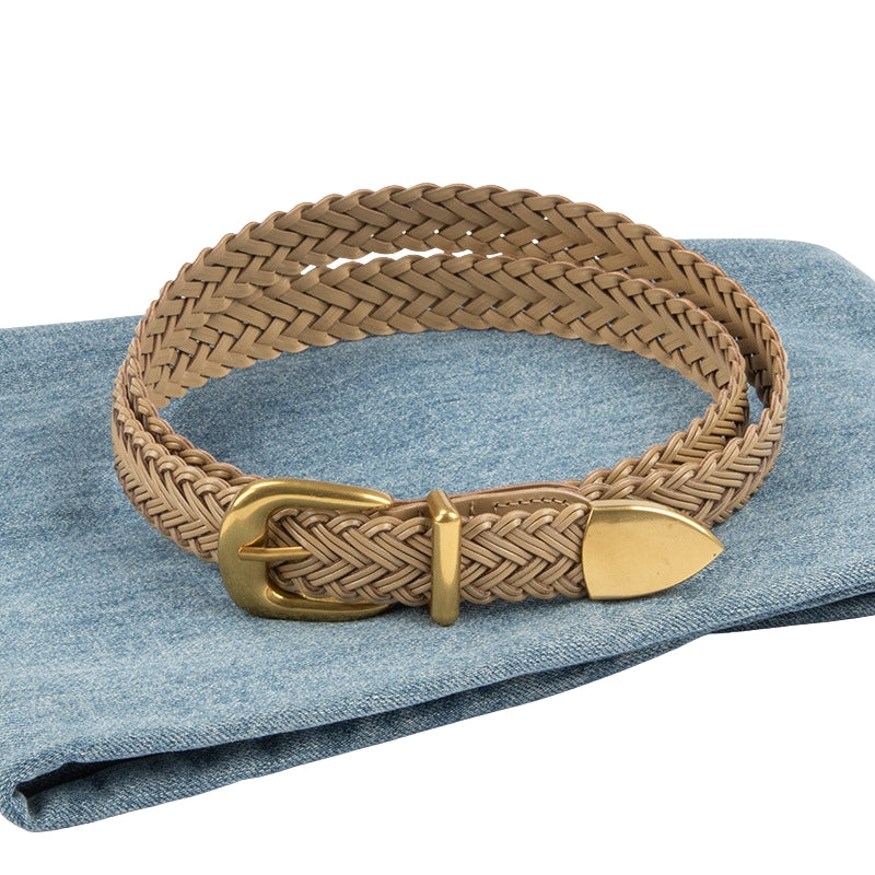 Ceinture Lison tressée en simili-cuir beige avec boucle ardillon dorée et embout pointu, posée sur un tissu en jean bleu #fullwidth