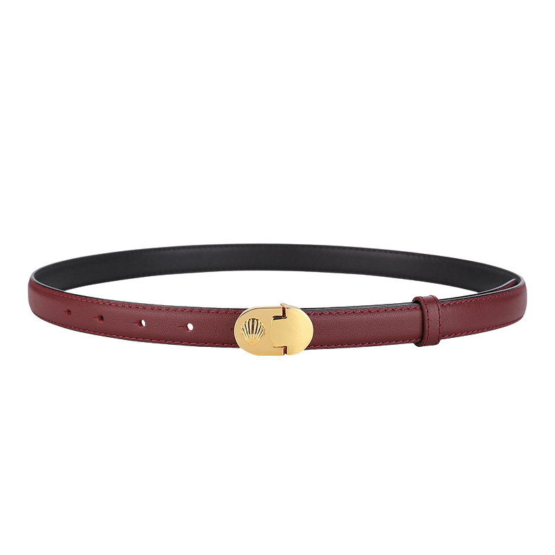 Ceinture fine en cuir refendu de vachette bordeaux, avec une boucle ovale dorée à motif coquillage embossé. Le système à crochet clou assure un maintien fiable. La ceinture Megève est un accessoire élégant et polyvalent.