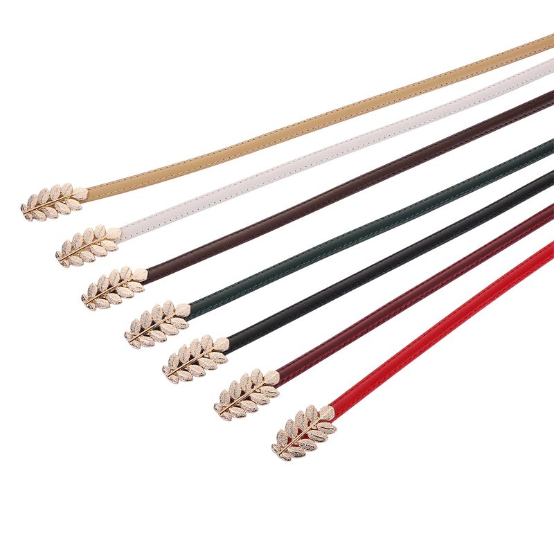 Ceinture fine Mélusine pour femme, disponible en plusieurs couleurs : beige, blanc, marron, vert, noir, bordeaux et rouge. Chaque ceinture est dotée d'une boucle bijou dorée en forme de double feuille.