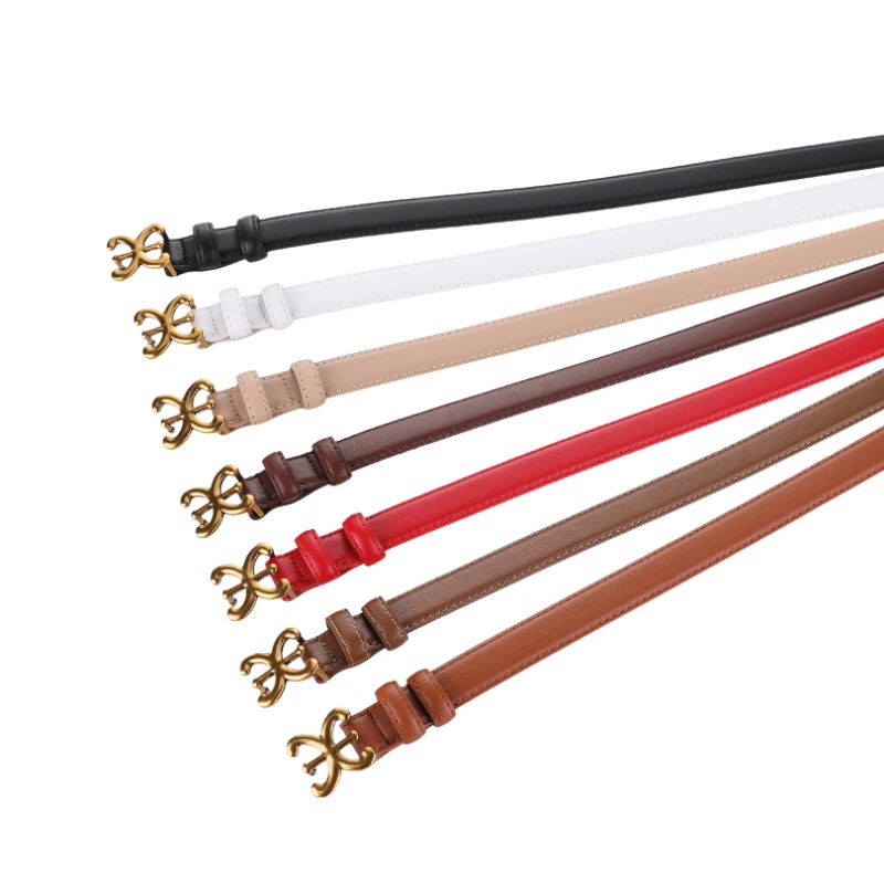 Collection de ceintures fines Nacre pour femme en cuir de vachette, disponibles en noir, blanc, beige, marron foncé, rouge et marron clair, avec boucle ardillon dorée en forme de nœud floral stylisé.