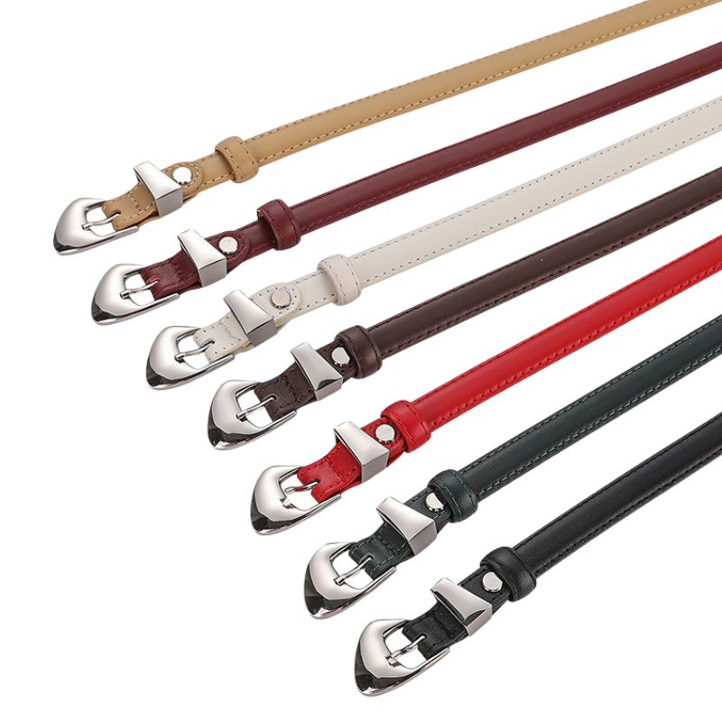 Ceinture fine Ysée en cuir pleine fleur de vachette, disponible en plusieurs coloris : beige, bordeaux, blanc cassé, marron foncé, rouge, vert forêt et noir. Boucle ardillon argentée.